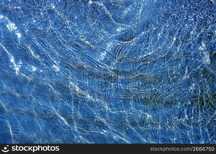 blue shallow water wavy reflection on beach coastline