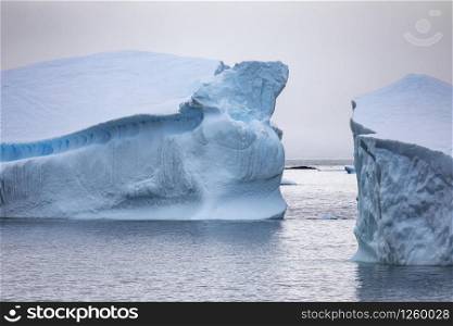 Blue shimmering opening between two icebergs offers road to sea in Antarctica