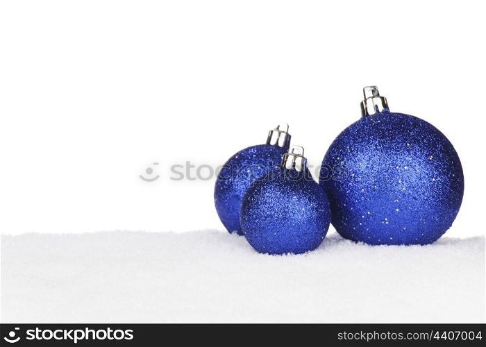 Blue shiny Christmas balls on snow