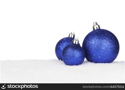 Blue shiny Christmas balls on snow