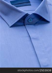 blue shirt with a focus on the collar and button, close-up. cotton shirt, close-up