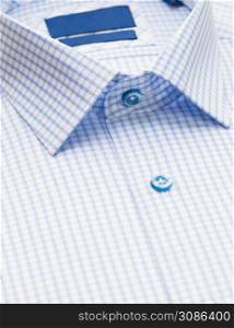 blue shirt with checkered pattern and with a focus on the collar and button, close-up. cotton shirt, close-up