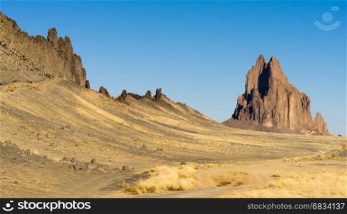 Blue skies appear in a panoramic view of Shiprock