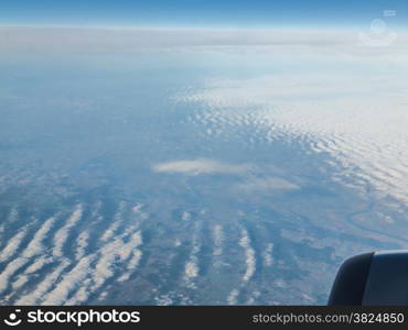 Blue sky and engine. View from window of airplane flying in clouds. Skyscape cloudscape. Bird&#39;s eye.