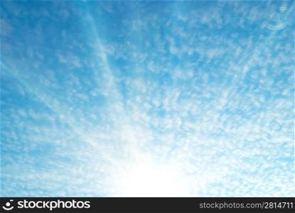Blue sky and white clouds. Sunrise with sun and sunbeams.