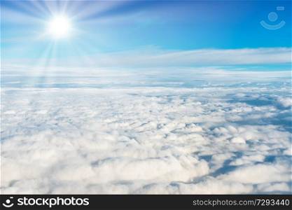 Blue sky and white clouds with sun rays view from plane