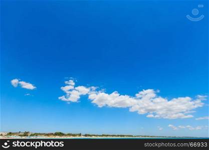 Blue sky background with white clouds and sea coast.