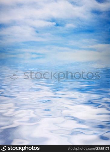 blue sky covered with the film of the clouds and reflection in water