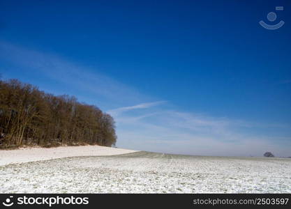 Blue sky over a wide open winter landscape near the Dutch village Simpelveld in the province Limburg. Wide open winter landscape near the Dutch village Simpelveld