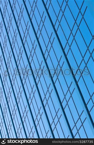 Blue sky reflecting in the windows of a modern skyscraper office block