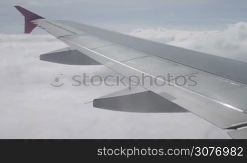 Blue sky with clouds. An aerial view from airplane. Clouds and Airplane wing seen from the window of an aircraft.