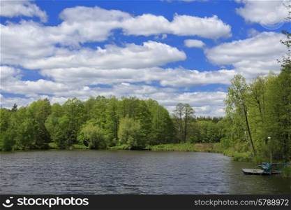 Blue sky with clouds, lake and forest at sunny day&#xA;