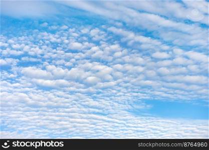 Blue sky with white clouds in sunny day. Beauty clear cloudy sky in sunshine calm air background. Natural background texture, backdrop, wallpaper, element for design