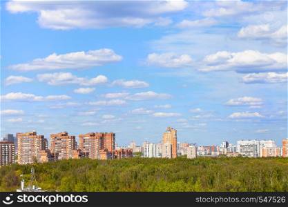 blue sky with white clouds over city park and residential district in sunny spring day