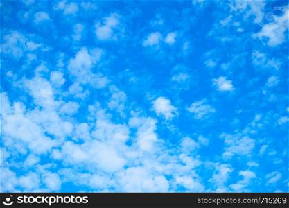 Blue sky with white fleecy clouds, may be used as background