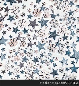 Blue stars and snowflakes pattern on white background. Top view. Creative holiday concept. Flat lay. White blue colors. Winter layout