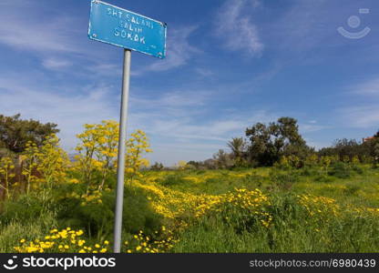 Blue street sign against yellow and green spring fields and sky in Diorios village in the island of Cyprus