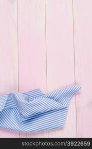 Blue striped towel over the surface of a wooden table.