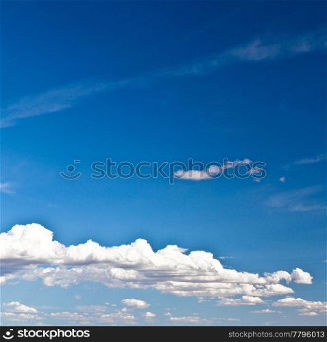 Blue summer sky with low white clouds with copy space
