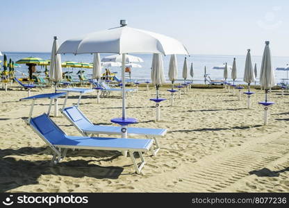 Blue sunbeds and umbrellas on the beach.