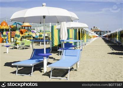 Blue sunbeds and umbrellas on the beach.