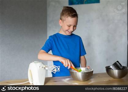 blue t-shirt, cooking, two bowls, metal bowls, pizza dough, mix ingredients, kitchen work, wooden table, baking, baby in the kitchen, trying dough, finger in mouth, mixer, cooking, dessert, pastry chef, pawar, kitchen. A child prepares dough in metal bowls. mix the ingredients