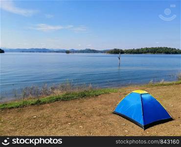Blue tent and vast lake view, bright sky