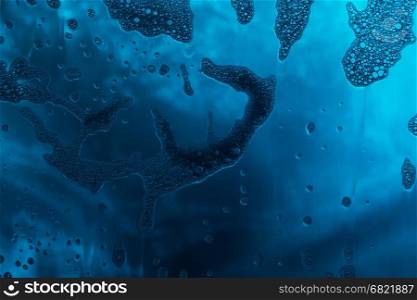 Blue texture with natural soap foam pattern on glass
