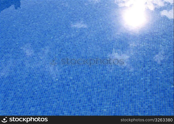 blue tiled swimming pool with sun reflexion summer vacation background