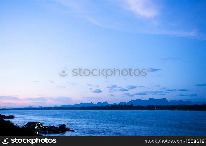 Blue tone sunset sky over Mae Khong river in Nakhon Phanom. Natural border between Thailand and Laos. Peaceful twilight scenery
