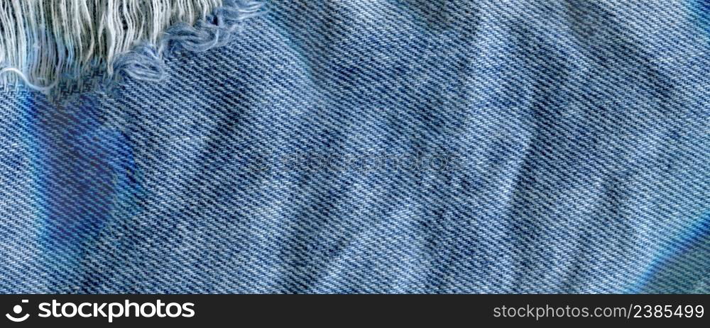 Blue torn grunge denim jeans texture. Jeans bit torn. Blue denim jean texture background. Jeans torn fabric texture