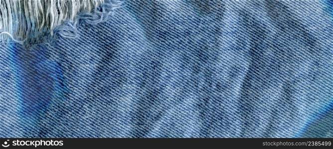 Blue torn grunge denim jeans texture. Jeans bit torn. Blue denim jean texture background. Jeans torn fabric texture