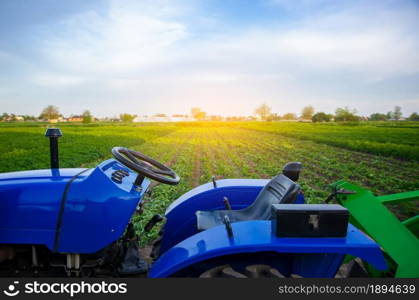 Blue tractor on farm field. Agricultural machinery and technology. Farming and vegetable growing. Modernization. Subsidies and tax refunds for purchase of new equipment. Agriculture and agro industry