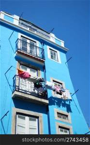 blue traditional building with clothes drying at the window