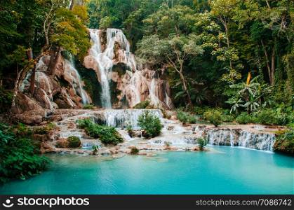 Blue turquoise water pond Kuang Si waterfall among rain forest in Luang Prabang, Laos during summer season.
