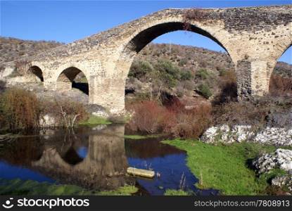 Blue water in river and old bridge near Salihli, Turkey