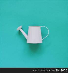 Blue watering can on green background&#xA;