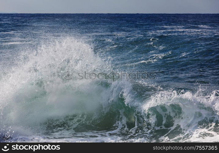 Blue wave on the beach. Blur background and sunlight spots. Dramatic natural background.