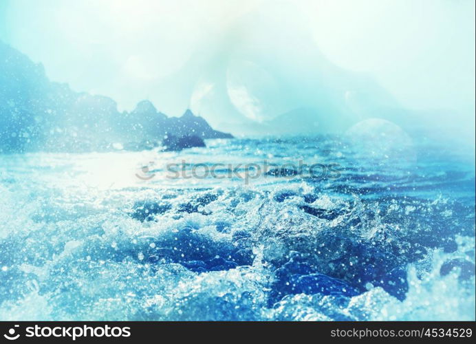 Blue wave on the beach. Blur background and sunlight spots. Peaceful natural background.