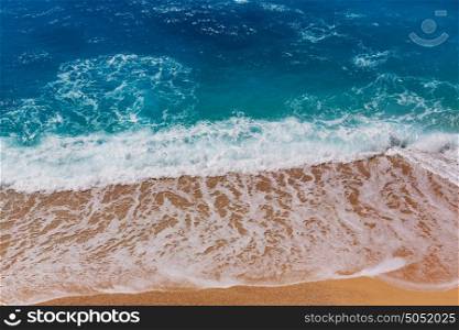 Blue wave on the beach. Blur background and sunlight spots. Peaceful natural background.