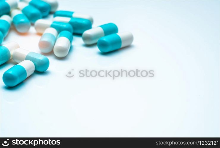Blue-white capsule pills on white background. Antibiotic drug resistance concept. Capsule pills sampling in pharmaceutical industry. Antimicrobail medicine. Pharmacy product. Medication for infection.