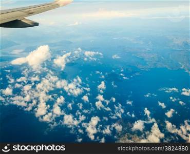 Blue white cloudy sky and plane. View from window of airplane flying in clouds over Norway Scandinavia. Skyscape cloudscape.
