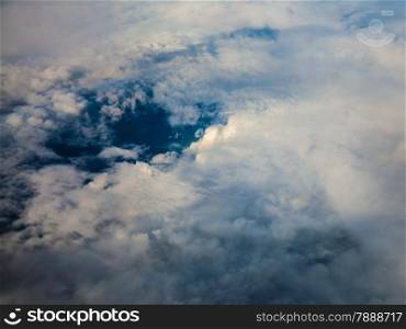 Blue white cloudy sky. View from window of airplane flying in clouds. Skyscape cloudscape. Bird&#39;s eye.