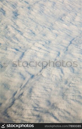 Blue white cloudy sky. View from window of airplane flying in clouds. Skyscape cloudscape. Bird&#39;s eye.