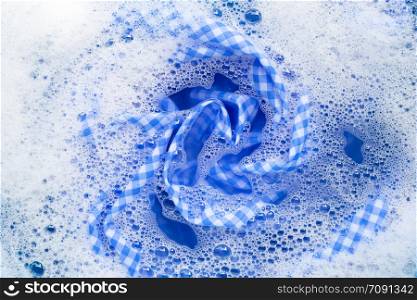Blue white tablecloth soak in powder detergent water dissolution, washing cloth. Laundry concept