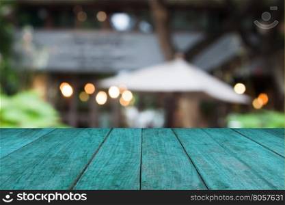 Blue wooden table top with cafe blurred abstract background