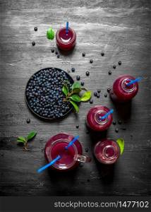 Blueberries and blueberry juice. On a black wooden background.. Blueberries and blueberry juice. On black wooden background.