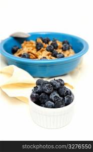 Blueberries And Cereal. Bowl of cold breakfast cereal with fresh blueberries on a white background