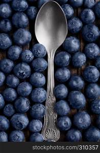 Blueberries around spoon close up photo. Natural healthy food. Still life photography