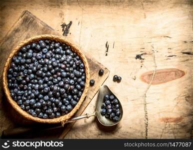 Blueberries in a Cup with a spoon. On a wooden table.. Blueberries in cup with a spoon.